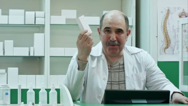 Médecin aîné amical avec des médicaments présentant des pilules — Video