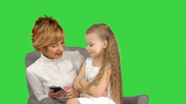 Fiatal nő-anya és gyermeke meg telefonon egy zöld képernyő, chroma key — Stock videók