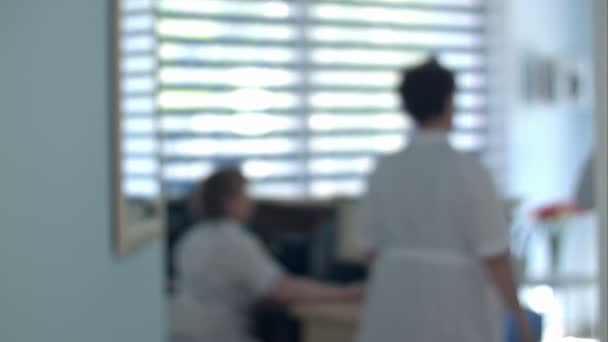 Réception hospitalière occupée avec médecins et réceptionnistes — Video