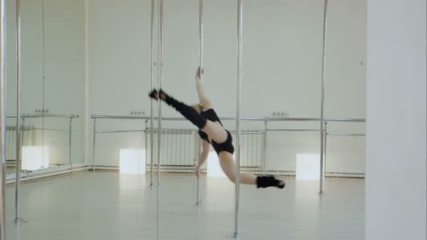 Improbable pole dancer makes a split while hangs upside down on a pylon in the studio — Stock Video