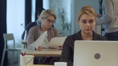 Modern ofis dizüstü bilgisayarda çalışan genç kadın