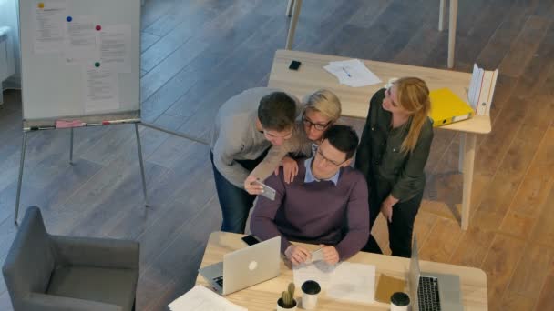 一组同事在其办事处同时考虑与智能手机拍照开心 — 图库视频影像