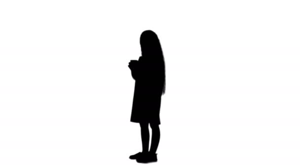 Silhouette χαριτωμένο κοριτσάκι χαμογελά και χρησιμοποιεί ένα κινητό τηλέφωνο κομμάτι ματ — Αρχείο Βίντεο