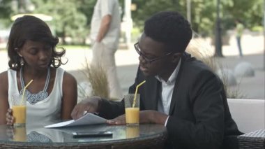 Bir kahve dükkanında bir toplantı yaparken ayrıntıları açıklayan belgeler, holding Afro-Amerikan iş adamları