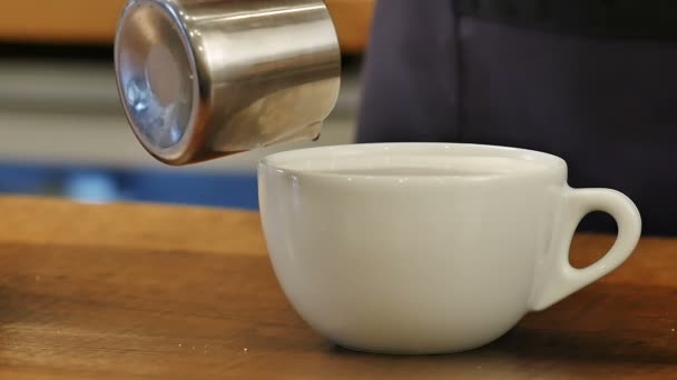 Versare il caffè nella tazza con il latte — Video Stock