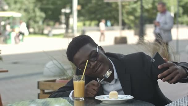 Щасливий афро-американський бізнесмен бере селфі в кафе — стокове відео