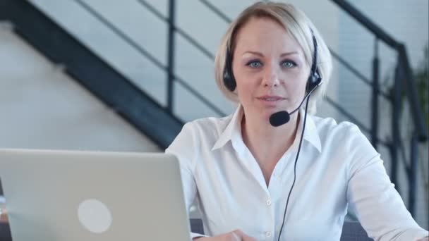 Hermosa mujer de servicio al cliente de negocios sonriendo hablando con una cámara en el centro de llamadas — Vídeo de stock