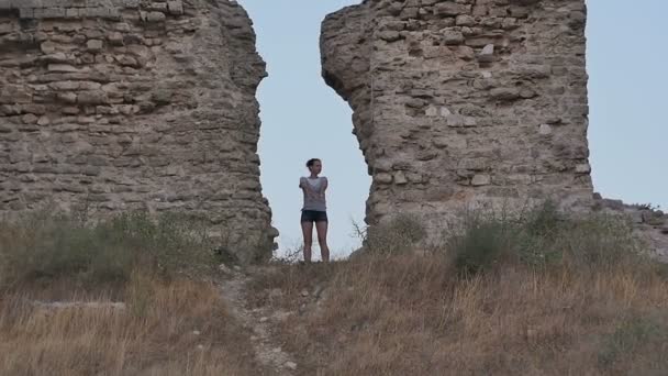 Ανέμελη γυναίκα ταξιδιώτης κάνει αστείο χορό κοντά στα αρχαία τείχη — Αρχείο Βίντεο
