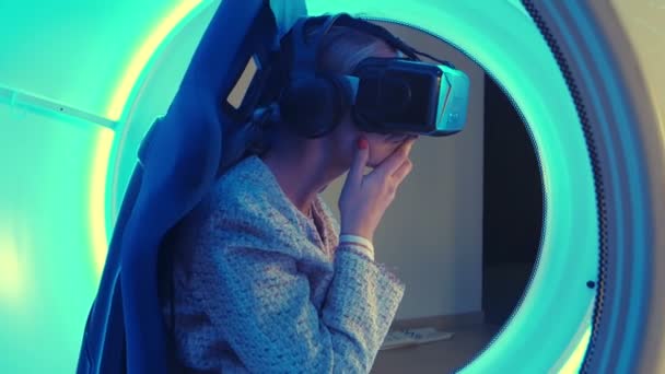 Молодая женщина в гарнитуре виртуальной реальности выбирает игру для vr-сессии — стоковое видео