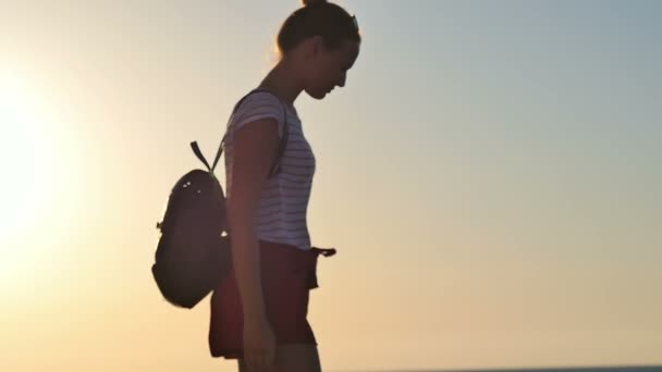 Jeune femme profitant d'un beau coucher de soleil sur la plage — Video