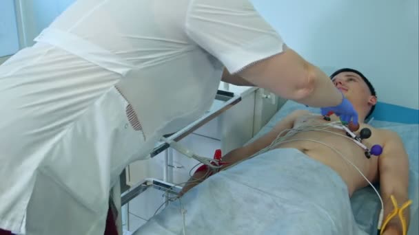 Enfermera quitando las almohadillas de ECG del paciente masculino — Vídeos de Stock