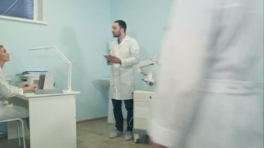 Dizüstü bilgisayarlar farklı sorular üzerinde çalışan tıbbi personel soran tablet ile genç adam
