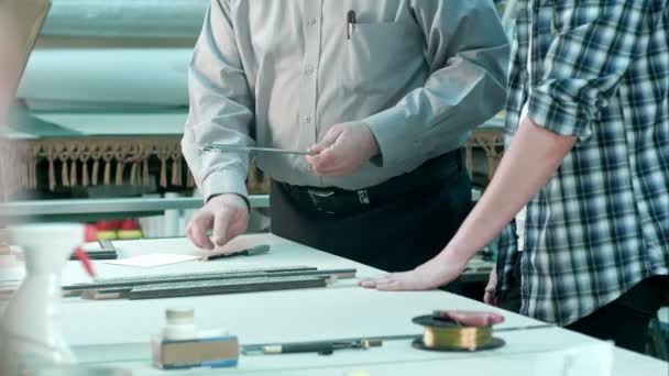 Trabajadores masculinos midiendo el tamaño del marco detrás del escritorio en el taller — Vídeo de stock