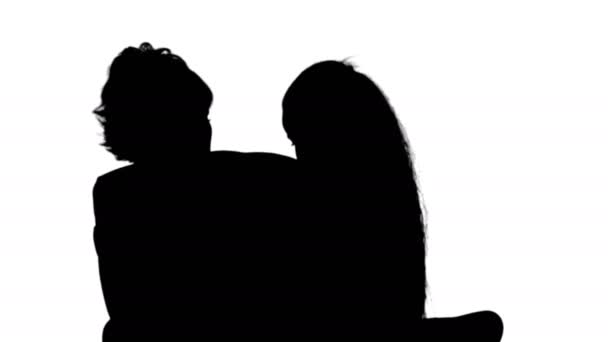 Silhouette Mutter und Tochter lesen Buch auf der Couch — Stockvideo