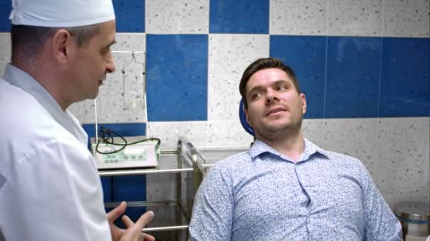 Profesyonel diş hekimi diş kliniği, onun genç erkek hasta ile konuşmak — Stok video
