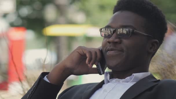 Bello afroamericano uomo ride e parla sul suo cellulare — Video Stock