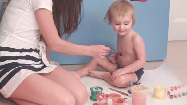 Madre pintando en su pequeño cuerpo de niño haciéndole cosquillas — Vídeos de Stock