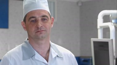 Erkek doktor dururken kamera bakıyor