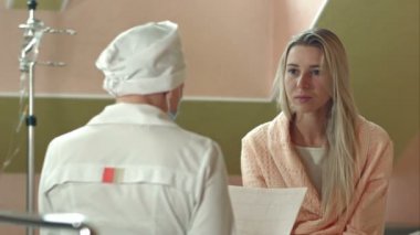 Genç kadın doktor prognoz için dinleme hastane yatağında üzgün