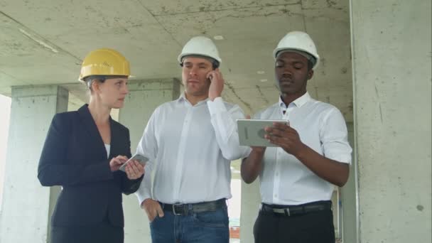 Equipo ejecutivo en el sitio de construcción de revisión con tableta, teléfono inteligente, personas vestidas formales lectura de tableta de construcción — Vídeos de Stock