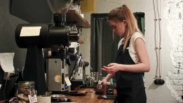 Bastante joven camarera pesando granos de café en una balanza antes de preparar una taza de café — Vídeos de Stock