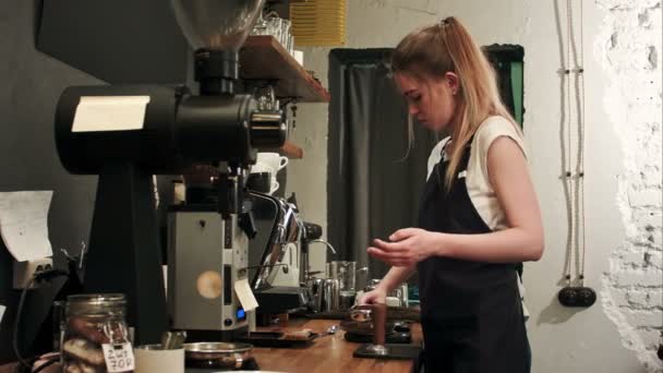 Bastante joven camarera pesando granos de café en una balanza antes de preparar una taza de café — Vídeo de stock