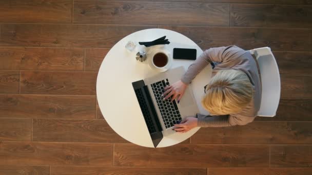 Jonge vrouw met laptop tijdens het zitten in cafe — Stockvideo