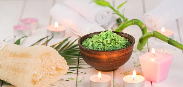 Spa. Sal de espirulina de hierbas verdes en tazón de cerámica, toallas de spa, vela perfumada rosa y bambú — Foto de Stock