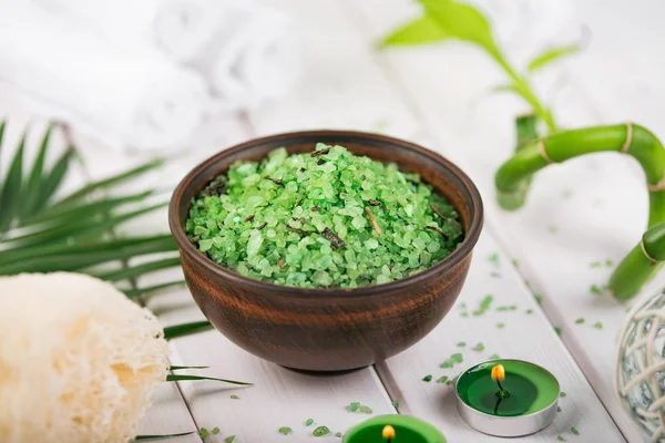 Spa. Sal de espirulina de hierbas verdes en tazón de cerámica, toallas de spa, velas y bambú — Foto de Stock