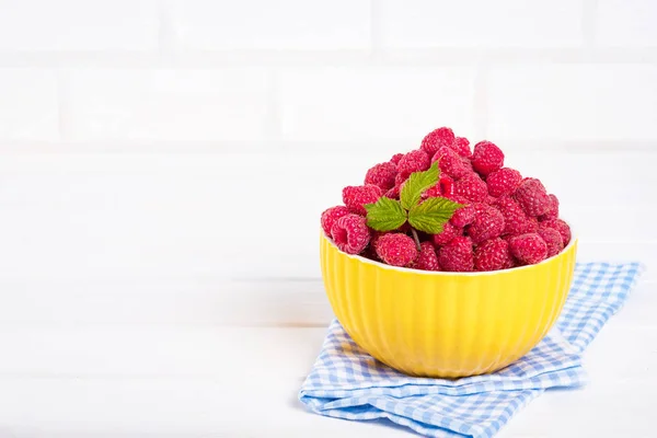 Fresh raspberry in a modern yellow bowl on light background — Stock Photo, Image