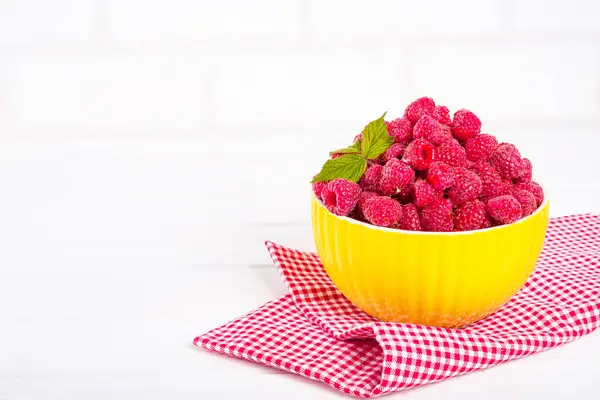 Fresh raspberry in a modern yellow bowl on light background — Stock Photo, Image