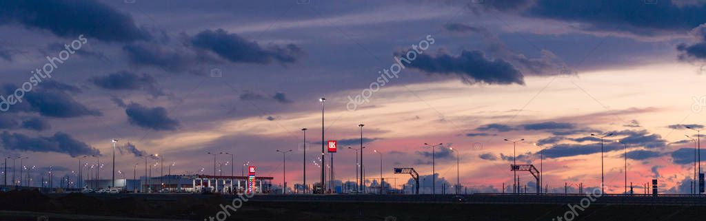 Taman, Russia - October 2018: Lukoil gas station on the Crimean Bridge at sunset, night. LUKOIL is a Russian oil company.
