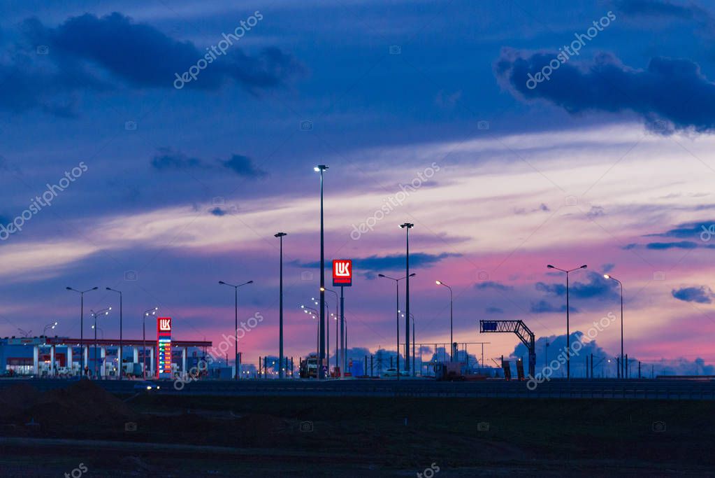 Taman, Russia - October 2018: Lukoil gas station on the Crimean Bridge at sunset, night. LUKOIL is a Russian oil company.