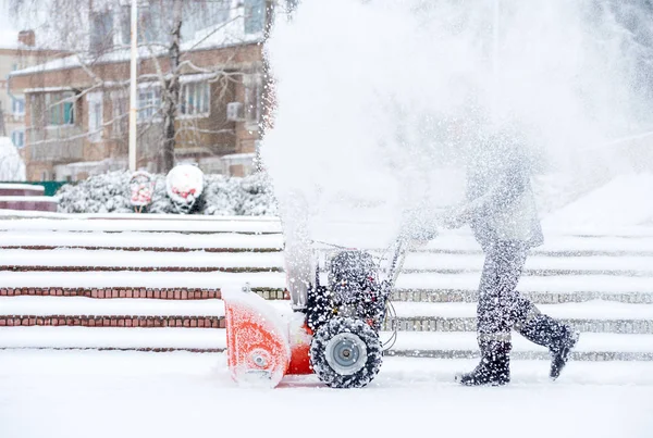 Schneeräumarbeiten mit einer Schneefräse. Mann räumt Schnee. Starke Niederschläge und Schneehaufen — Stockfoto