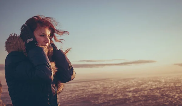 Jovem bela mulher menina desfrutando do pôr do sol no mar tempestuoso no inverno — Fotografia de Stock