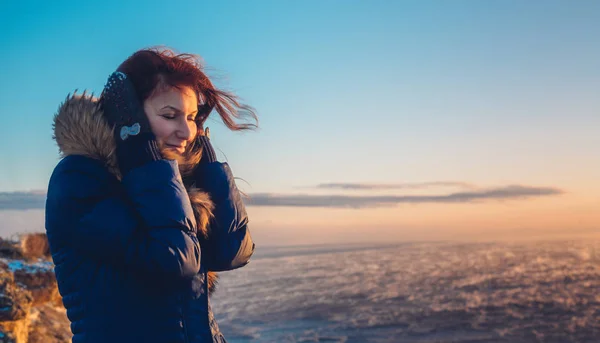 Jovem bela mulher menina desfrutando do pôr do sol no mar tempestuoso no inverno — Fotografia de Stock