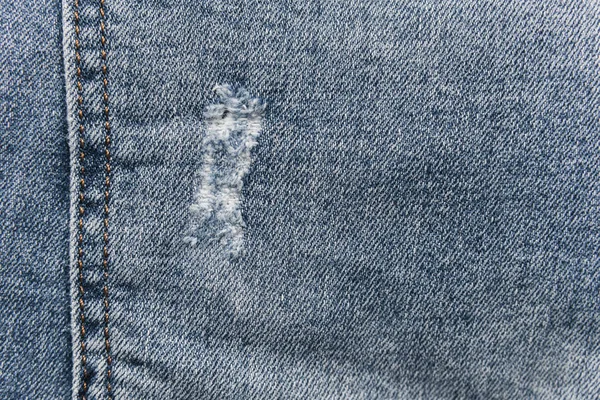 Denim azul jeans textura com arranhões e buracos. Contexto abstrato . — Fotografia de Stock