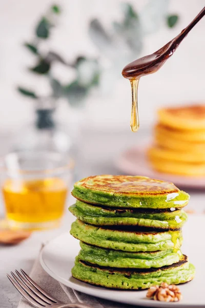 Gröna plättar med matcha te eller spenat, klädd honung och röda druvor. Hälsosam frukost med superfoods. Ljus bakgrund, Ing skandinavisk stil — Stockfoto