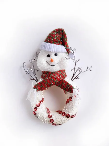 Snowman in a red cap and a red scarf on a white background