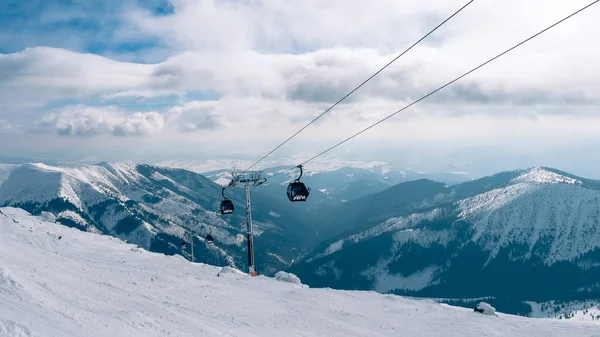 Elevador de góndola. Cabina de telesilla en la estación de esquí de Yasna al amanecer con pico de montaña en la distancia. Invierno snowboard y esquí concepto. Países Bajos — Foto de Stock