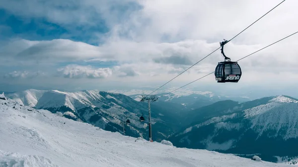 Elevador de góndola. Cabina de telesilla en la estación de esquí de Yasna al amanecer con pico de montaña en la distancia. Invierno snowboard y esquí concepto. Países Bajos — Foto de Stock