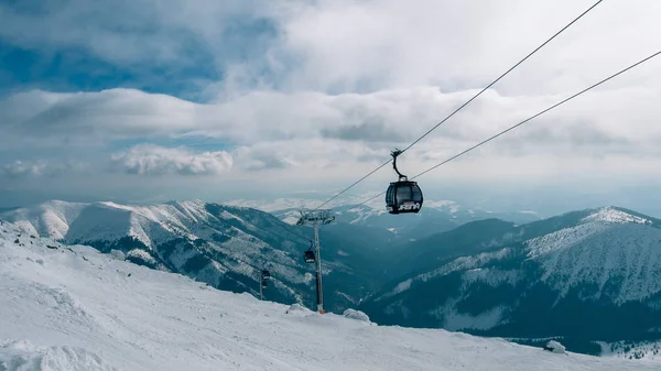 Elevador de góndola. Cabina de telesilla en la estación de esquí de Yasna al amanecer con pico de montaña en la distancia. Invierno snowboard y esquí concepto. Países Bajos — Foto de Stock