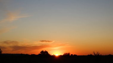 Mutlu yeni gün konsepti: Güzel bir tarlada yaz gündoğumu ve çarpıcı bir gökyüzü.