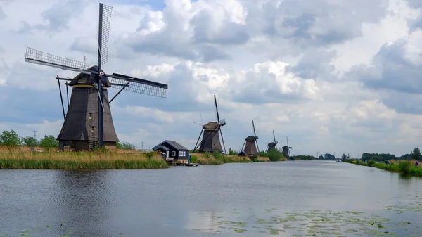 Kinderdijk, Hollanda - Mayıs 2019. O Kinderdijk 'in yel değirmenlerini ziyaret ederken turist bisikleti sürüyor. Kinderdijk 'in yel değirmenleri Hollanda' nın en tanınmış turistik alanlarından biridir..