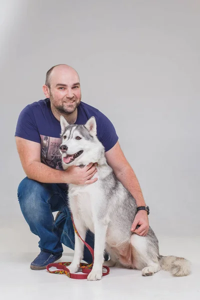 Hombre con perro siberiano husky —  Fotos de Stock