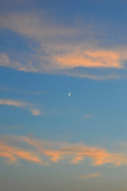 New moon ve akşam gökyüzünde turuncu bulutlar