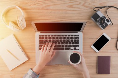 Laptop ve kahve en iyi görünümü kullanarak eller. Yeni nesil insanların çalışma ve Internet üzerinden seyahat planlama kavramı .