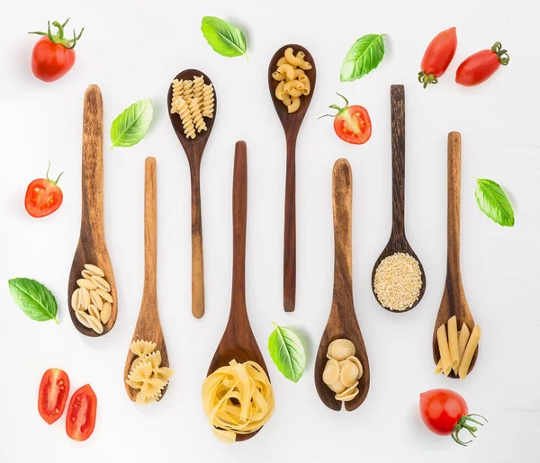 不同种类的面食在木勺和成分的白色背景从顶部的看法 意大利食品概念 — 图库照片