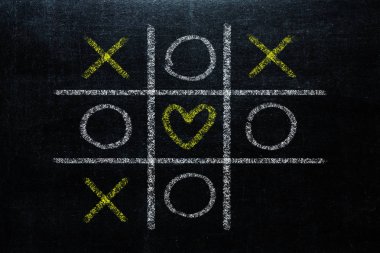 Soyut Tic Tac Toe oyunu yarışması kalp şeklinde merkezi. XO kazanmak kavramı meydan kara tahta üzerinde