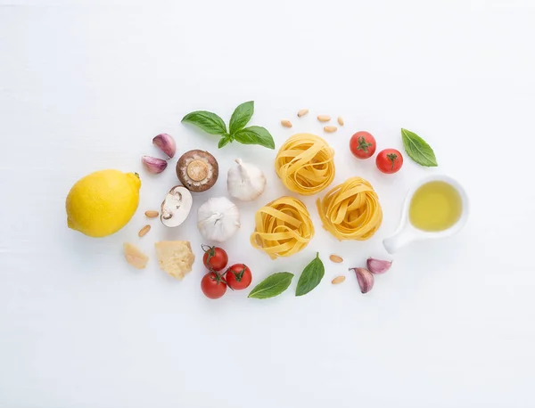 İtalyan yemeği arka plan, domates, limon, fesleğen, makarna, parmesan, zeytinyağı, sarımsak, çam fıstığı ve beyaz arka plan üzerinde mantar. Üstten görünüm